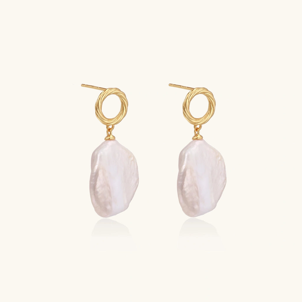 18K gold vermeil twisted circle studs with organic white baroque pearl drops on cream background