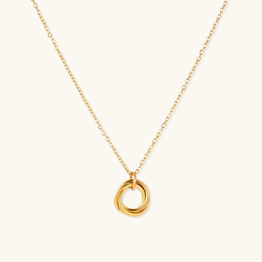 Delicate gold-plated necklace with three interlocking circle rings forming a minimalist knot pendant on cream background