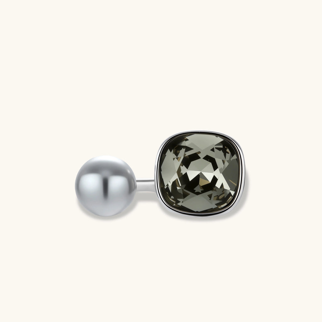 Open-cuff ring in white gold plated eco-brass with a smoky gray cushion-cut zirconia and a gray round bead on a cream background.