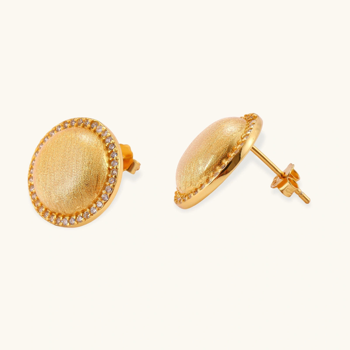 Pair of round dome stud earrings in brushed 18K gold-plated silver with a sparkling CZ halo border, push-back closure.