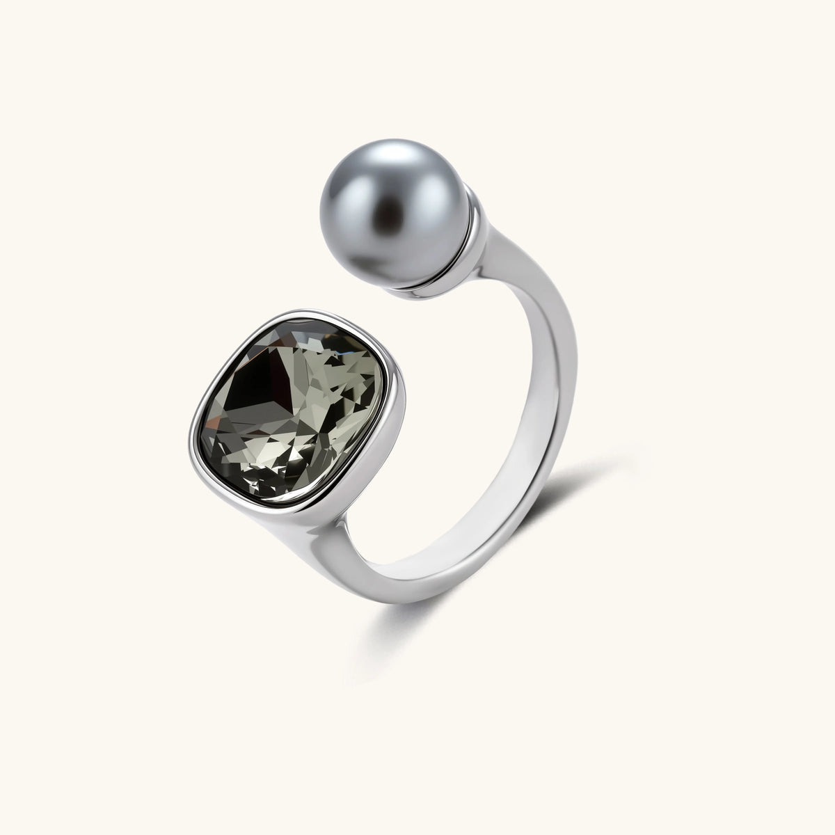 Open-cuff ring in white gold plated eco-brass with a smoky gray cushion-cut zirconia and a gray round bead on a cream background.